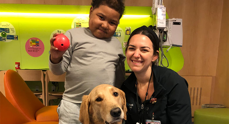 Image of little boy and nurse with dog