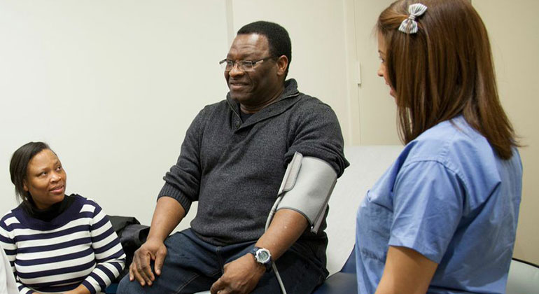 Patient getting his blood pressure taken by a nurse