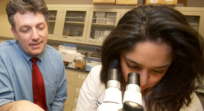 Image of Dr. Samuel Gandy, with student observing through microscope at the Center for Cognitive Health