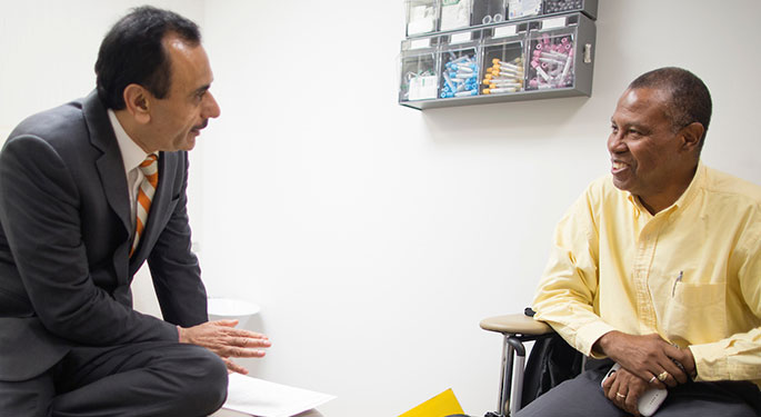 Image of Dr. Tewari speaking with male patient in Dr’s office