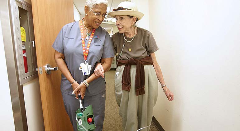 nurse walking with patient in ahll