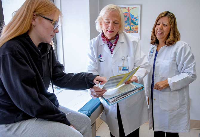 A photo shows Paige Dobbyn with her doctors, Patricia Walker, MD, and Maria Berdella, MD