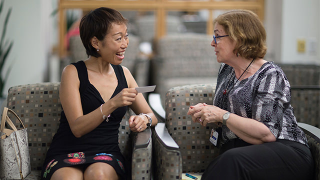 Two women speaking in waiting area