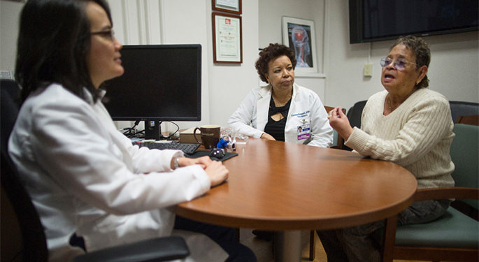 image of Dr. Fifi and faculty in discussion with patient, in an office setting