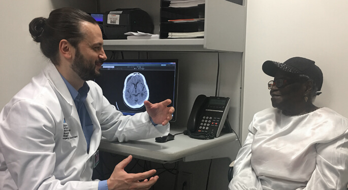 image of a doctor with patient in consulting room, reviewing brain scan