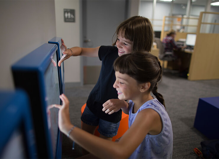 Photo of two girls playing on computer in waiting room
