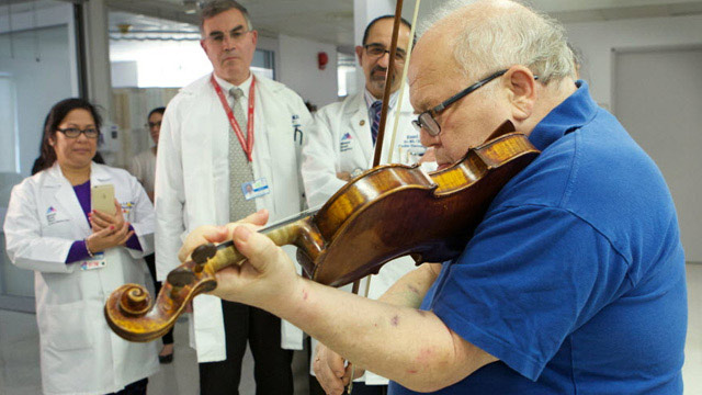 violin being played with doctors in background