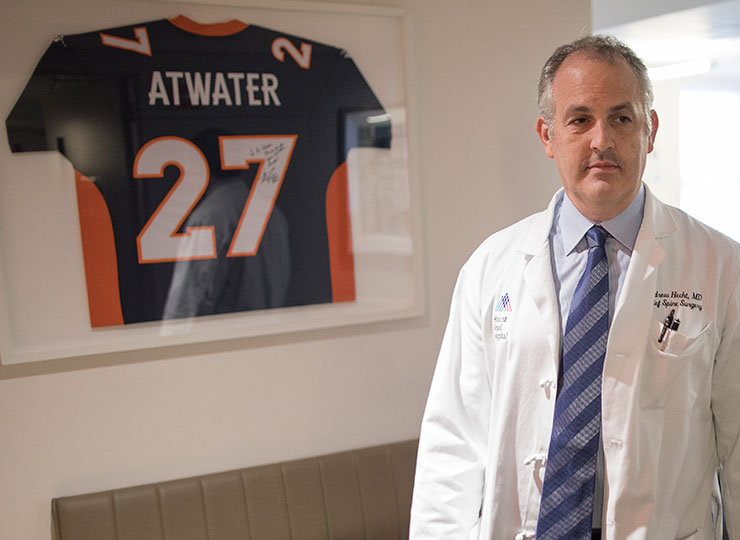 Photo of NFL Spine Program Dr. Hecht with NFL jersey in background