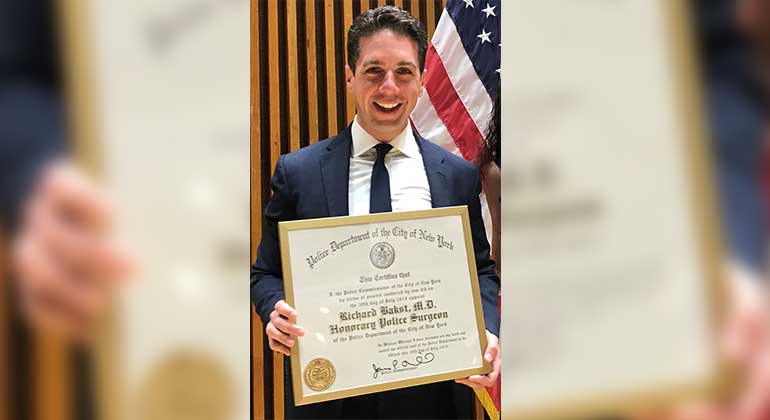 Dr. Richard Bakst holding an award,