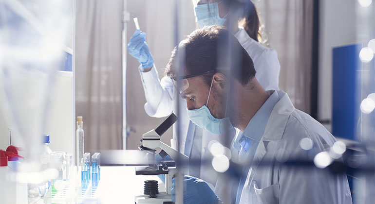 Researcher using microscope