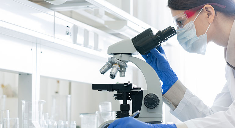 Researcher using microscope