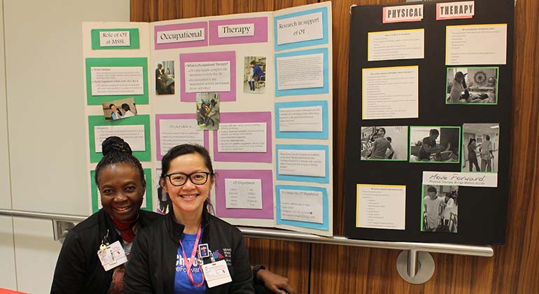 2 people in front of a poster