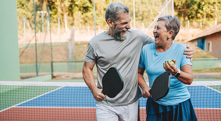 A man and a women side holding each other after a pickleball match