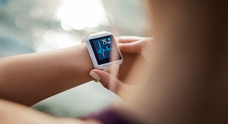 A female looking at her 75 bpm on her smartwatch