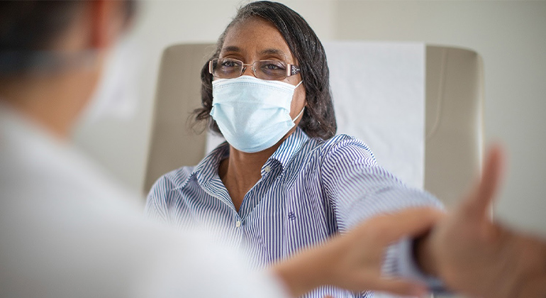 image of masked patient talking to doctor
