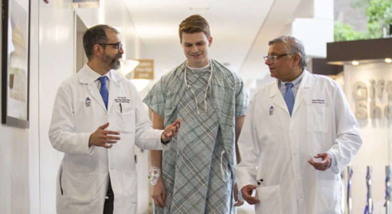 Image of two doctors and male patient walking down the hall