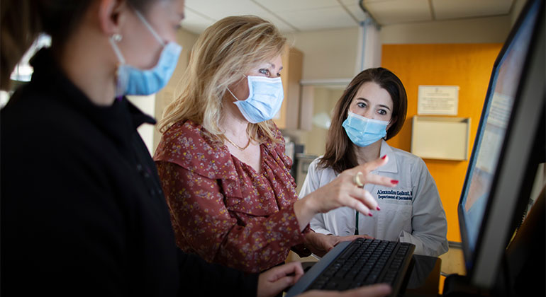 medical professionals reviewing material on computer