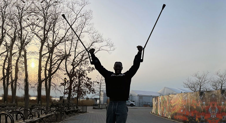 Cory Moses in park raising his crutches up in air