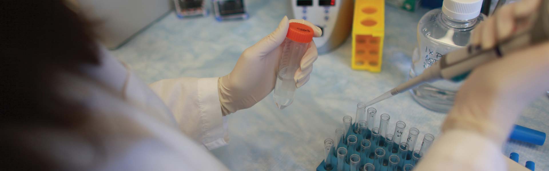 A researcher using a pipette in a lab