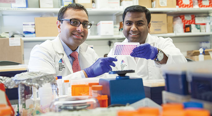 Two doctors using lab equipment