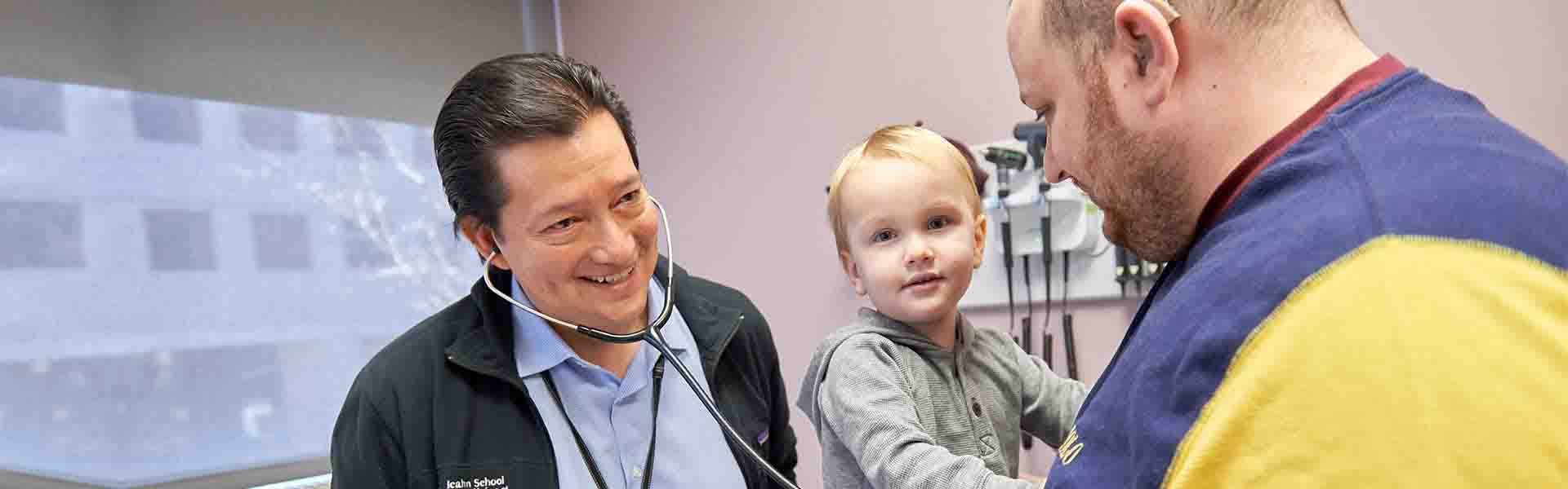 Doctor examining man, holding young boy