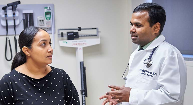 Female doctor in exam room, speaking with doctor