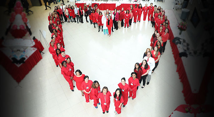 People in red forming a heart