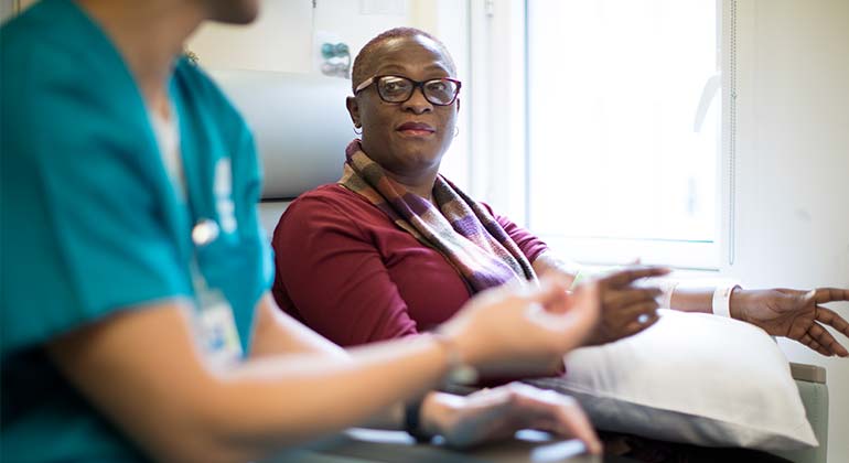 Nurse speaking to woman undergoing therapy