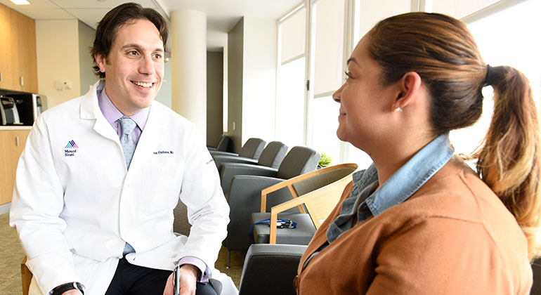 Doctor speaking to patient in waiting room