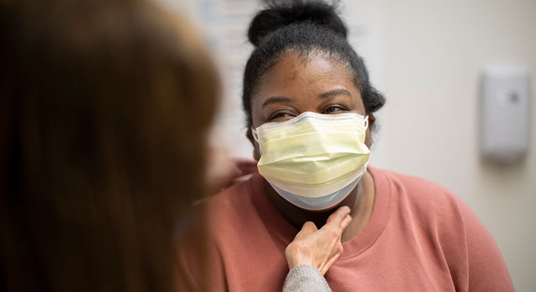 masked patient and doctor during an examination