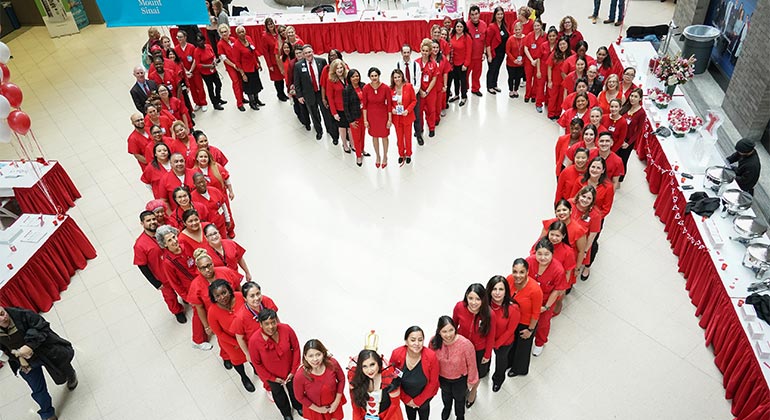 employees standing in a heart shape