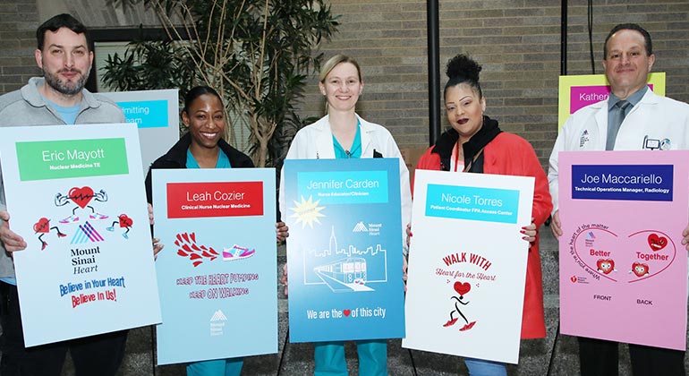 employees holding info signs