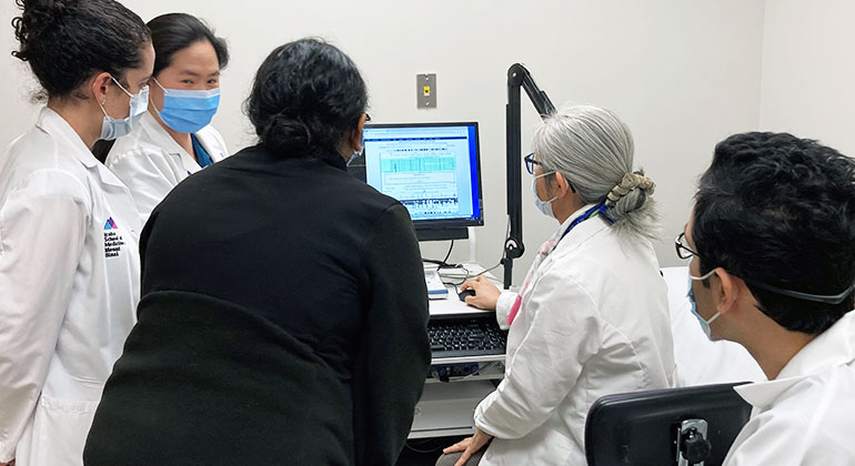 medical professionals  gathering around computer screen