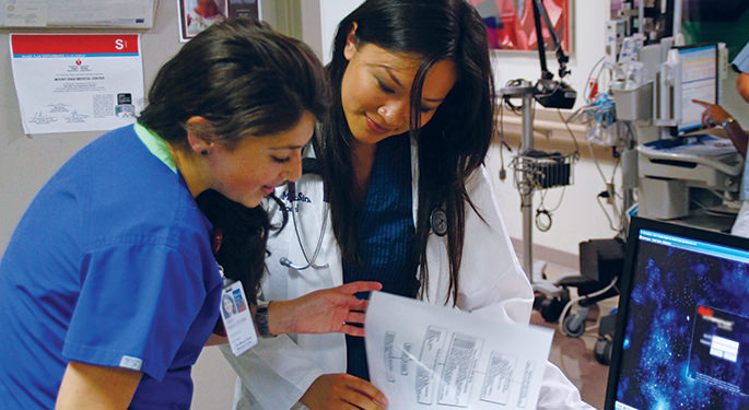 Image of attending doctor with resident reading lab report