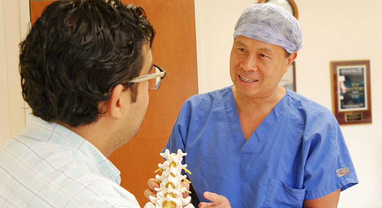 Doctors with model of spine