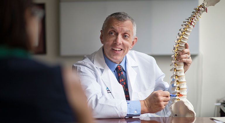 Doctor with model of spine