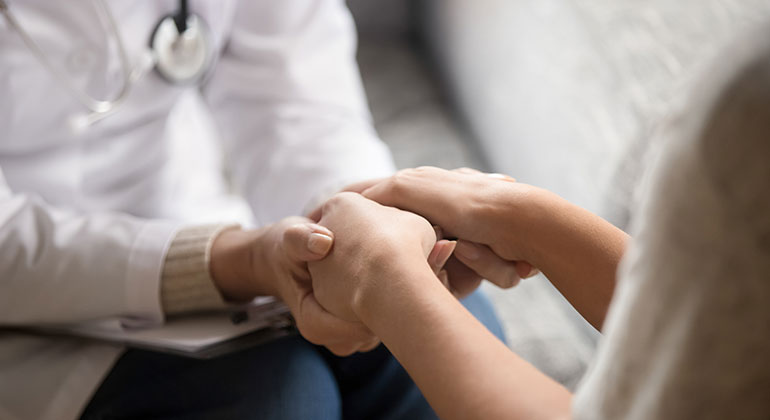 Image of doctor and patient holding hands