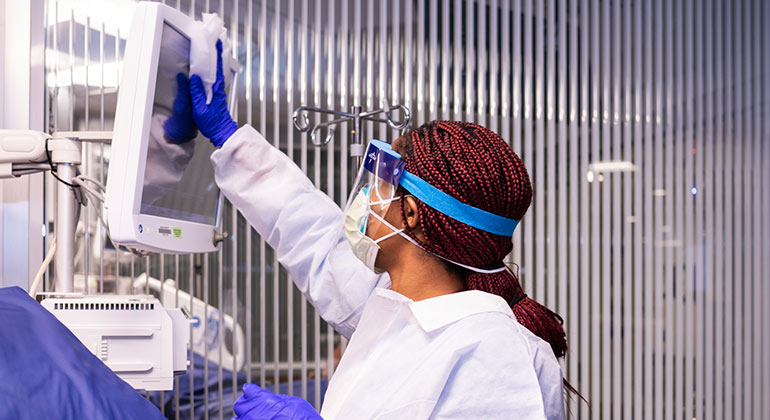 health care worker cleaning a screen
