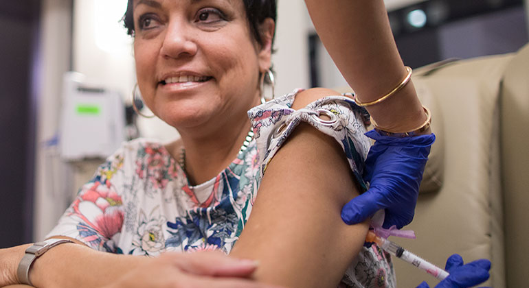 Injection going into woman’s upper arm