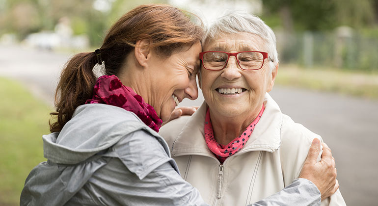 person hugging elderly person