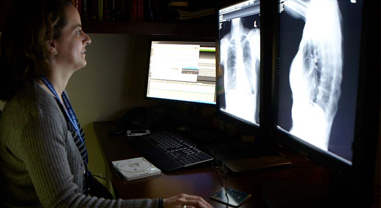 Image of female doctor looking at x-ray images