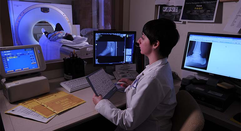 Image of female doctor looking at computer screens