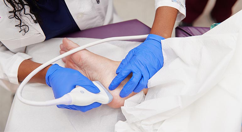 doctor performing sonogram on foot