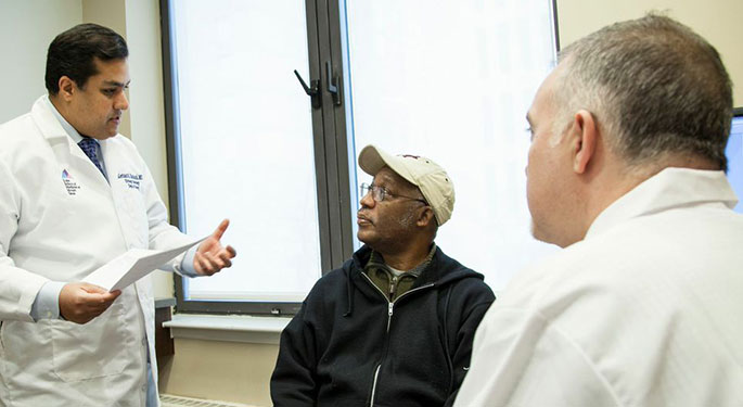 Doctors consulting male patient in Dr’s office