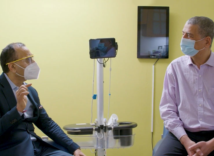 Photo of image of patient and doctor in an exam room 