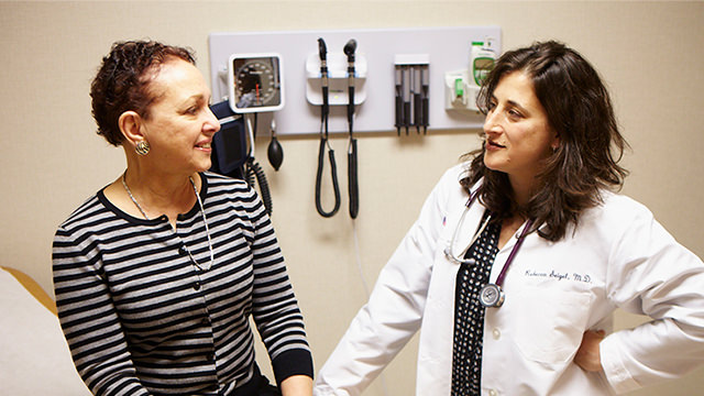 Doctor talking to patient in exam room