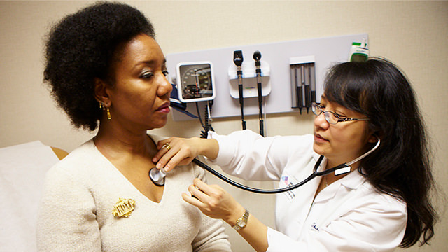 patient getting her heart rate checked by staff