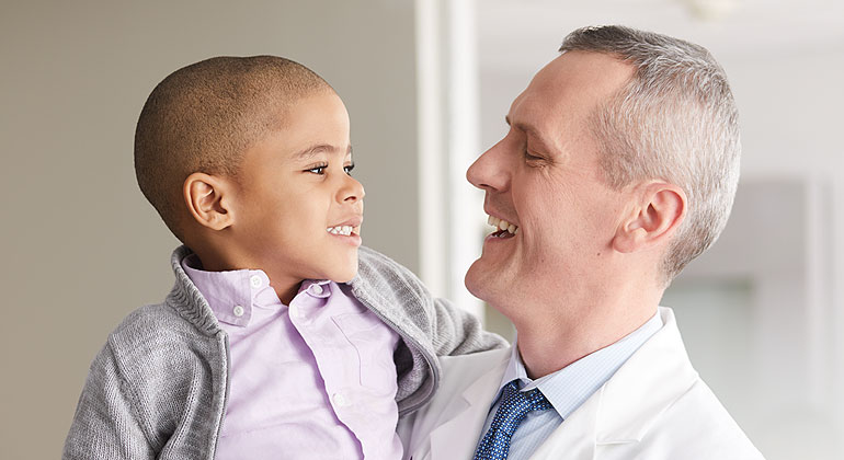 Doctor holding little boy