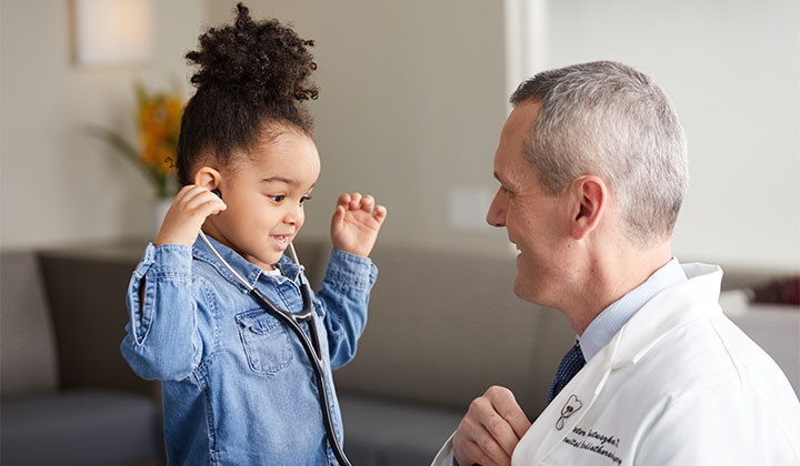 Little girl with stethoscope and doctor