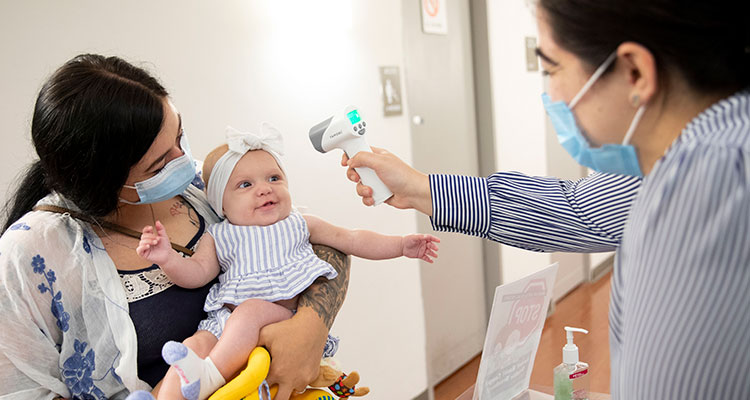 Image of nurse taking baby temperature
